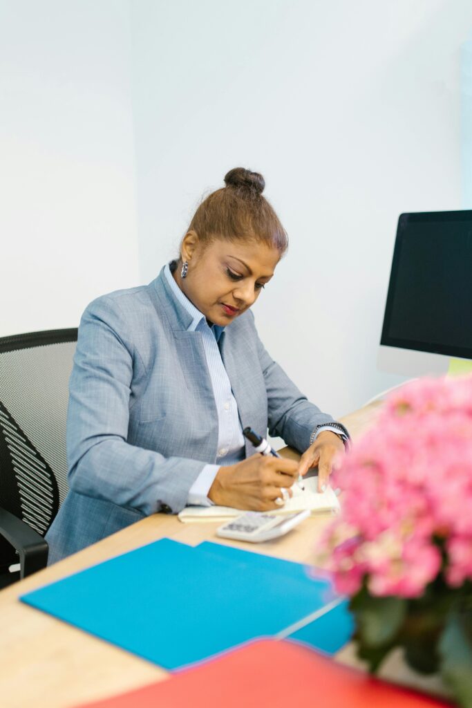 Confident woman in a modern office setting focusing on paperwork.